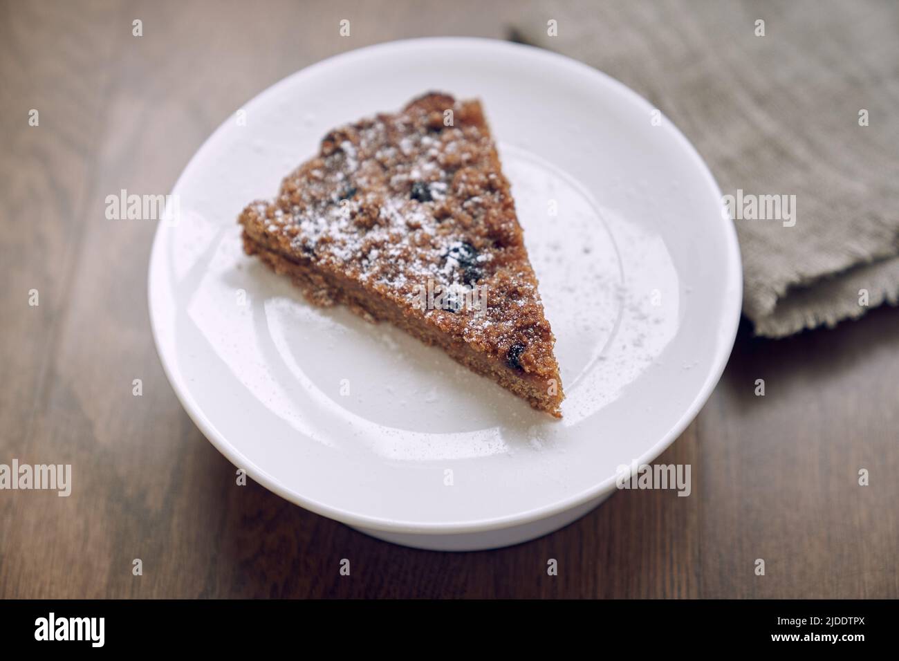 Un délicieux morceau de citronnelle avec des bleuets et des canneberges, sans lait ni œufs sur la farine de lin. Une partie de la tarte se trouve sur une plaque blanche sur la table. Le concept de saine alimentation. Haute qualité Banque D'Images Un délicieux morceau de citronnelle avec des bleuets et des canneberges, sans lait ni œufs sur la farine de lin. Une partie de la tarte se trouve sur une plaque blanche sur la table. Le concept de saine alimentation. Haute qualité Banque D'Images