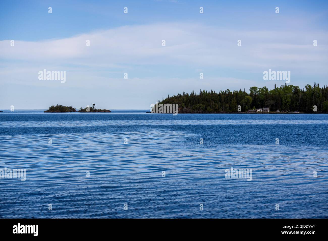 On peut voir quelques petits bâtiments de l'autre côté de la baie, dans le lac supérieur, au large des rives du parc national de l'Isle Royale Banque D'Images