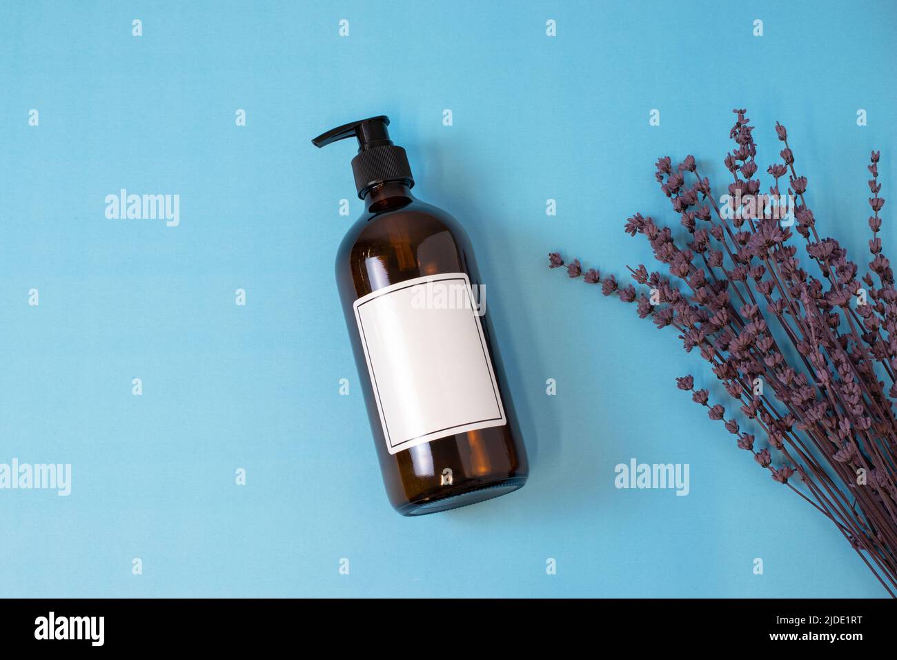 Videz le savon en verre ambré ou le flacon de shampooing sur un fond isolé. Soins de la peau ou concept de cheveux avec des cosmétiques naturels. Banque D'Images