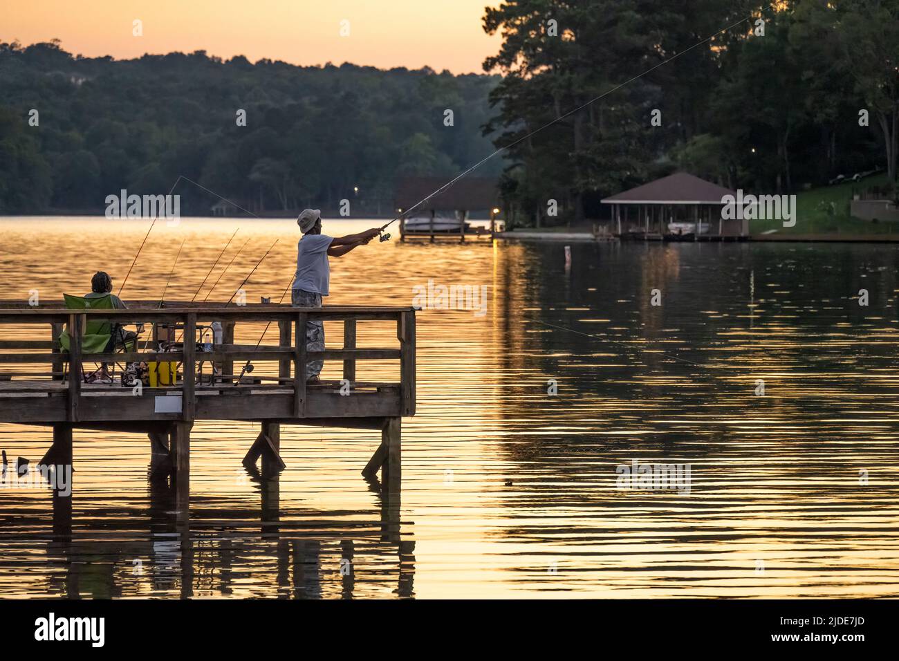 Couple pêchant à partir d'un quai de pêche au coucher du soleil sur le lac Oliver, un réservoir au-dessus du barrage Oliver entre Columbus, Géorgie et Phénix City, Alabama. (ÉTATS-UNIS) Banque D'Images