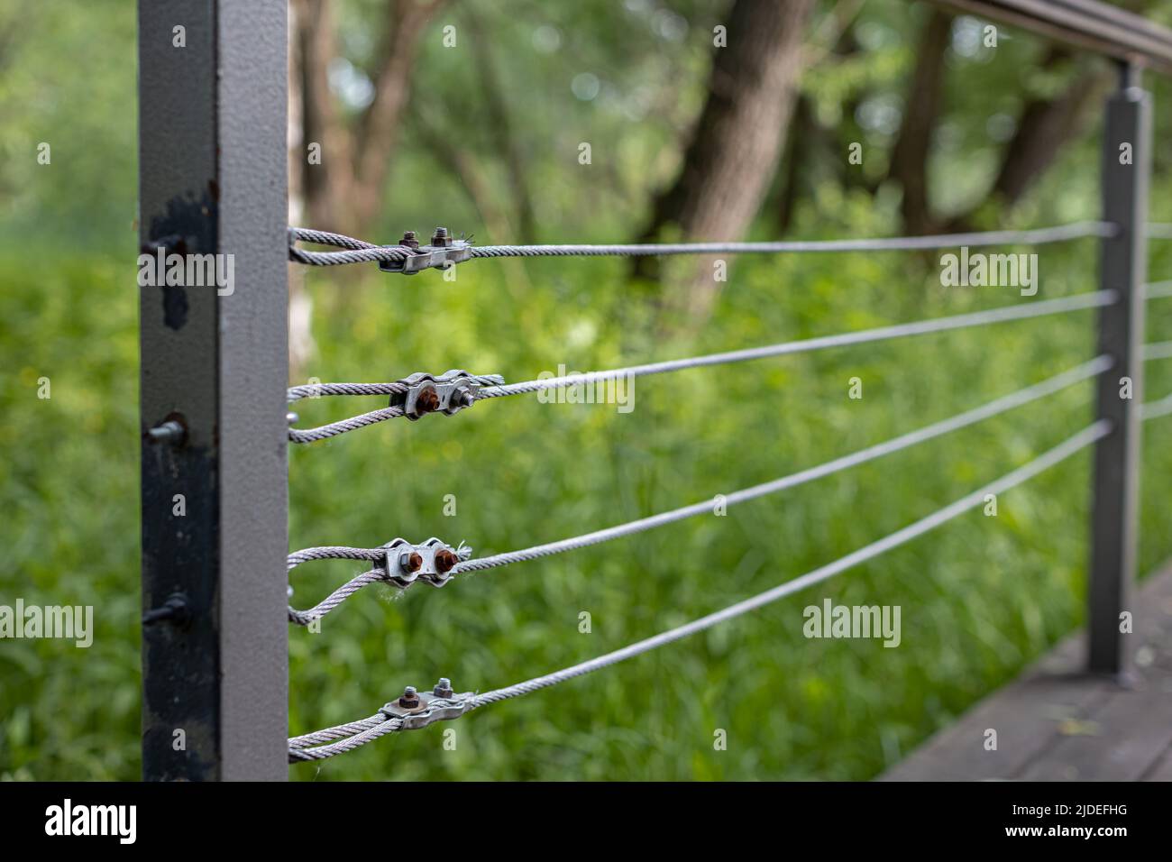 fixation d'un câble en acier sur une clôture dans un parc. Photo de haute qualité Banque D'Images