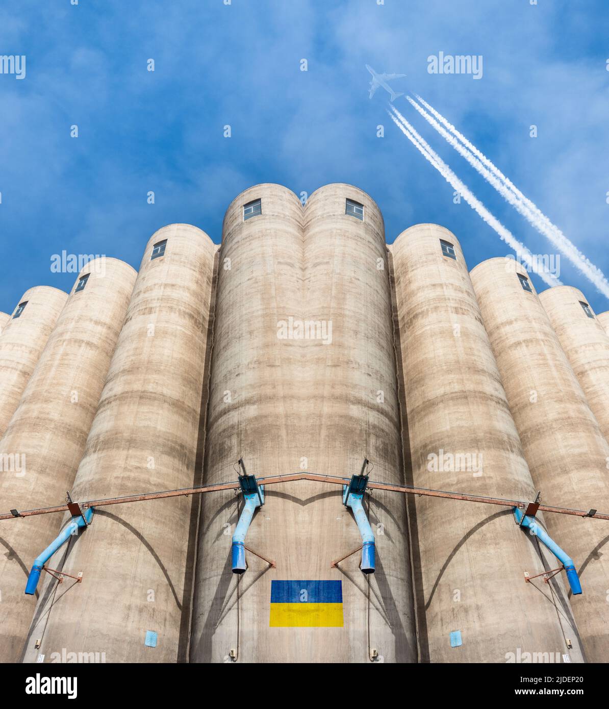 Silos à grains avec drapeau de l'Ukraine, avion volant au-dessus. Russie guerre de conflit, blé, pénurie alimentaire, prix... concept image composite Banque D'Images