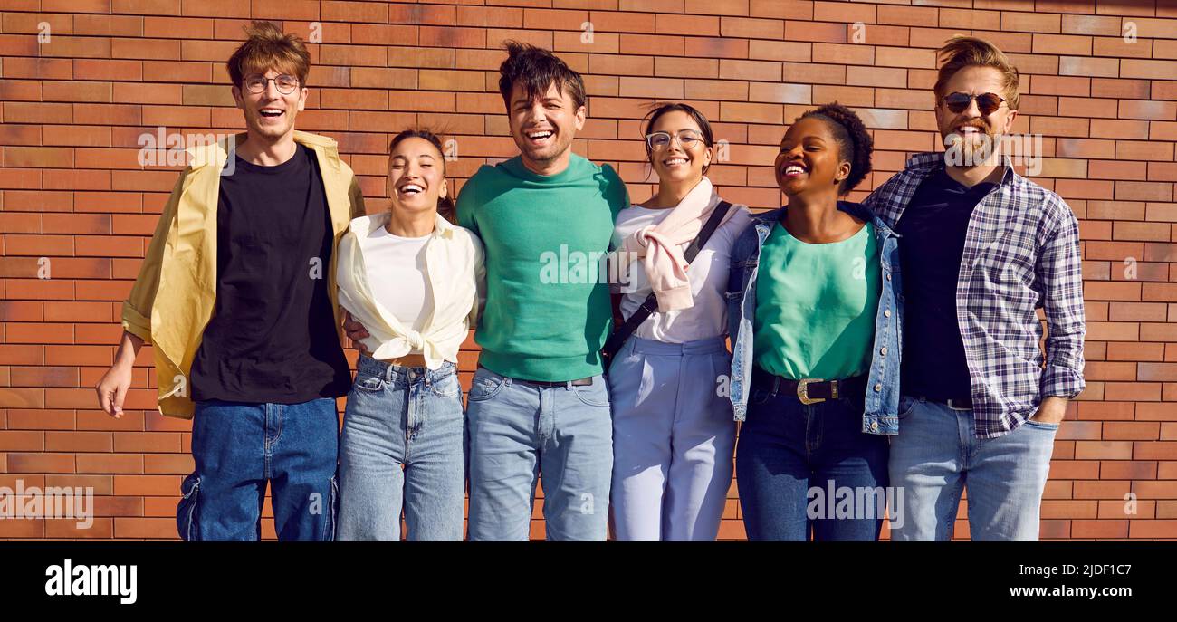 Joyeux joyeux jeunes amis multiraciaux dans des vêtements décontractés s'amusant tous ensemble dans la rue Banque D'Images