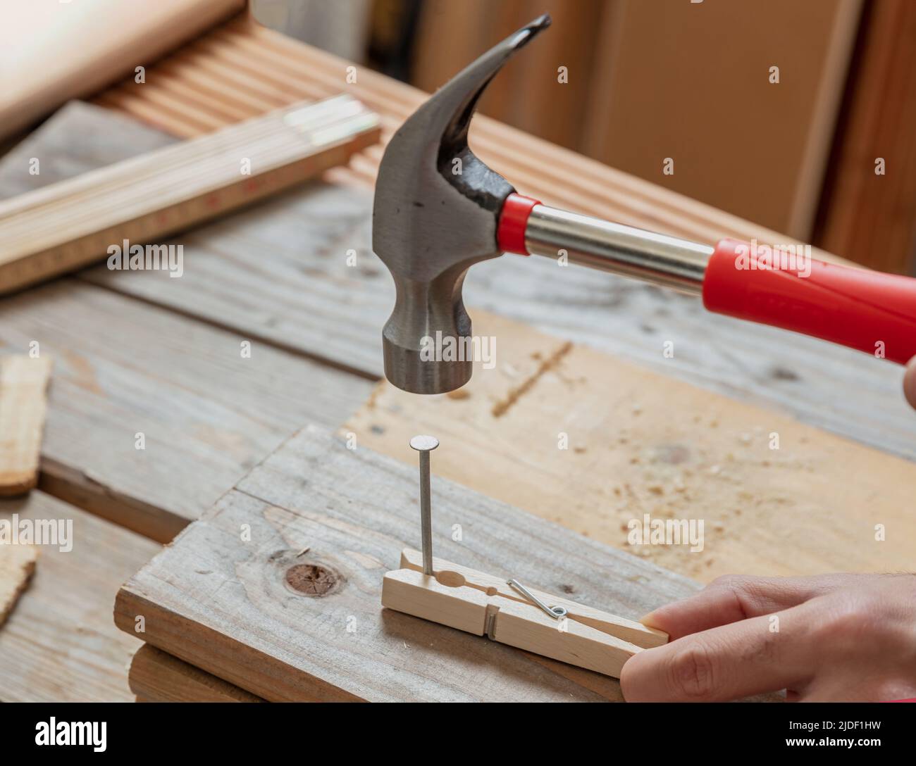 Un marteau et un clou à main mâle une goupille à linge, un arrière-plan de table de travail en bois.Bricolage, réparation et réparation à domicile. Banque D'Images