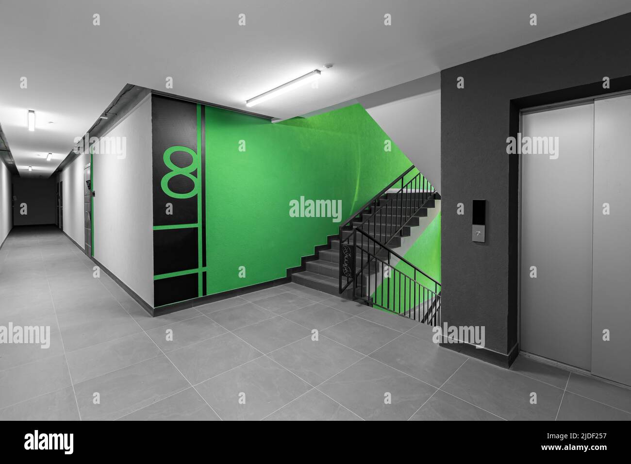 Couloir intérieur, avec porte d'entrée et ascenseur dans de nombreux immeubles d'appartements, avec boîtes aux lettres aux murs verts Banque D'Images