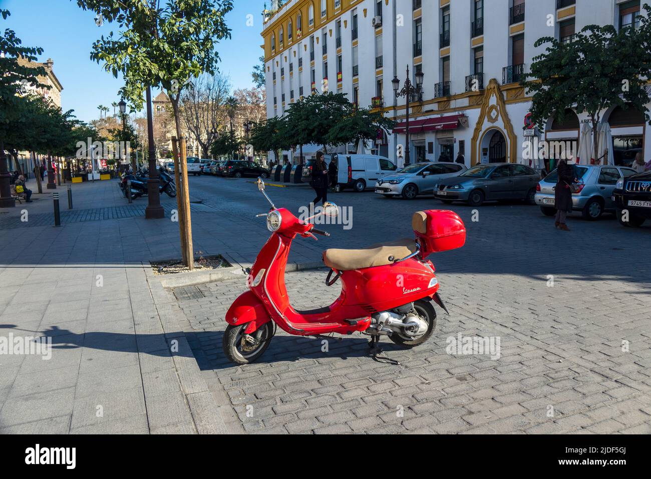 Vespa Scooter rouge vif garée dans le centre-ville de Séville en Espagne Banque D'Images