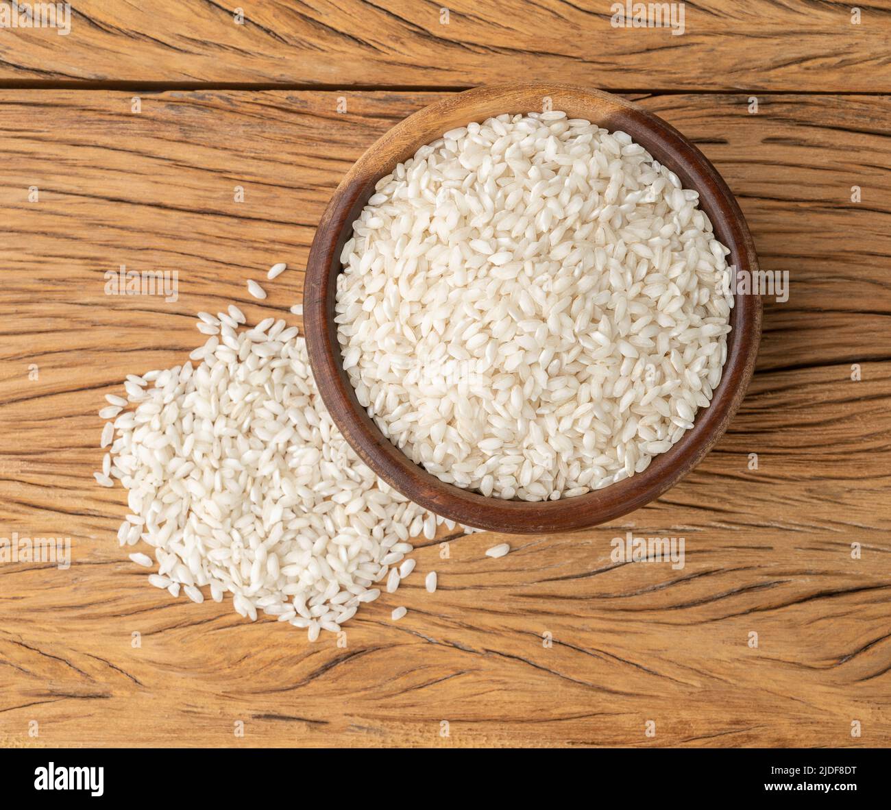 Riz carnaroli risotto cru dans un bol sur table en bois. Banque D'Images