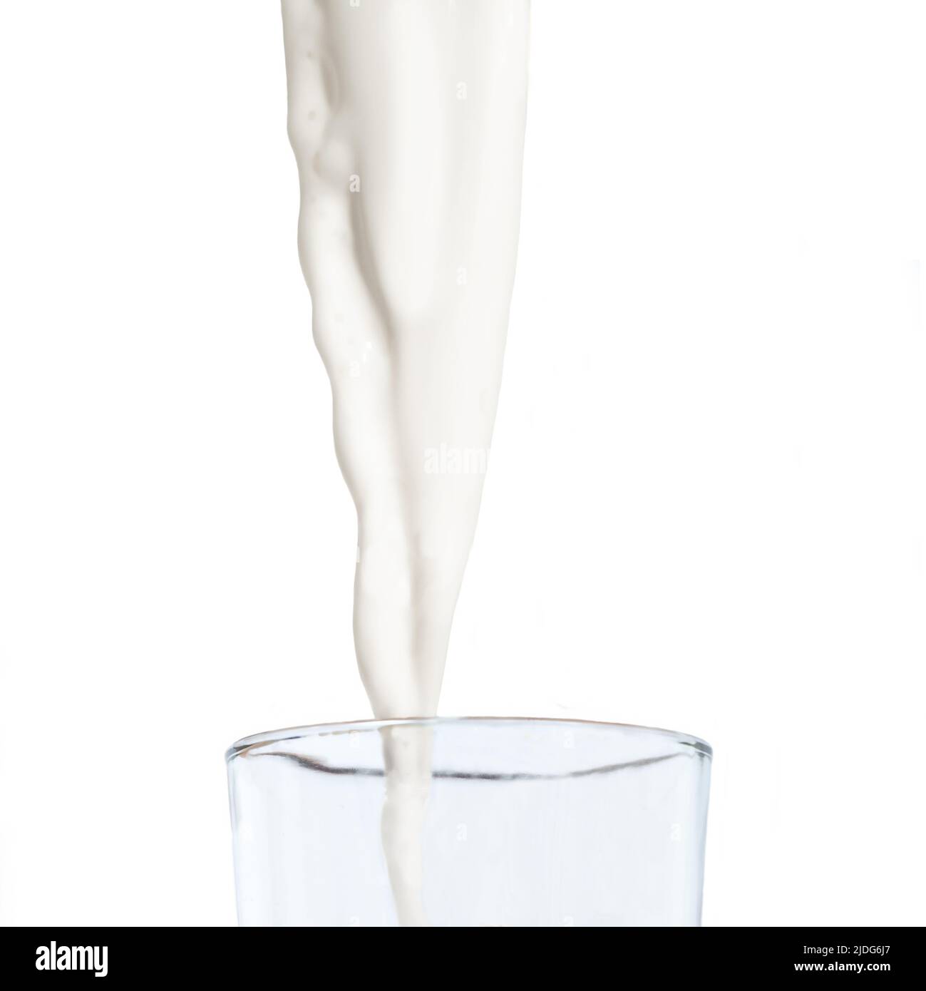 Le lait frais est versé dans un verre isolé sur fond blanc Banque D'Images