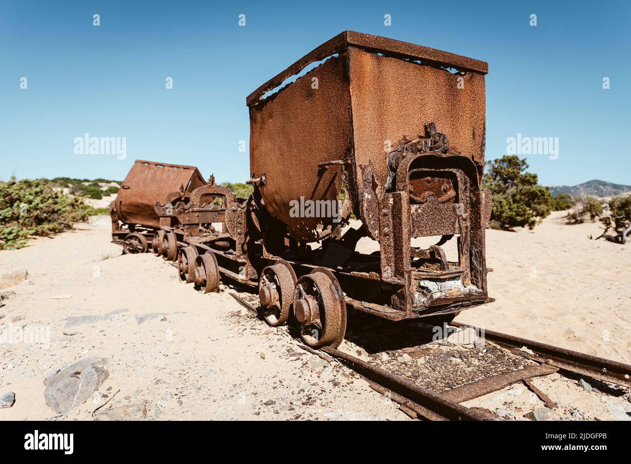 Wagons cassés rouillés et débris de chemin de fer des mines de plomb et de zinc aux dunes de sable près de la plage de Piscinas, Costa Verde, Sardaigne, Italie Banque D'Images