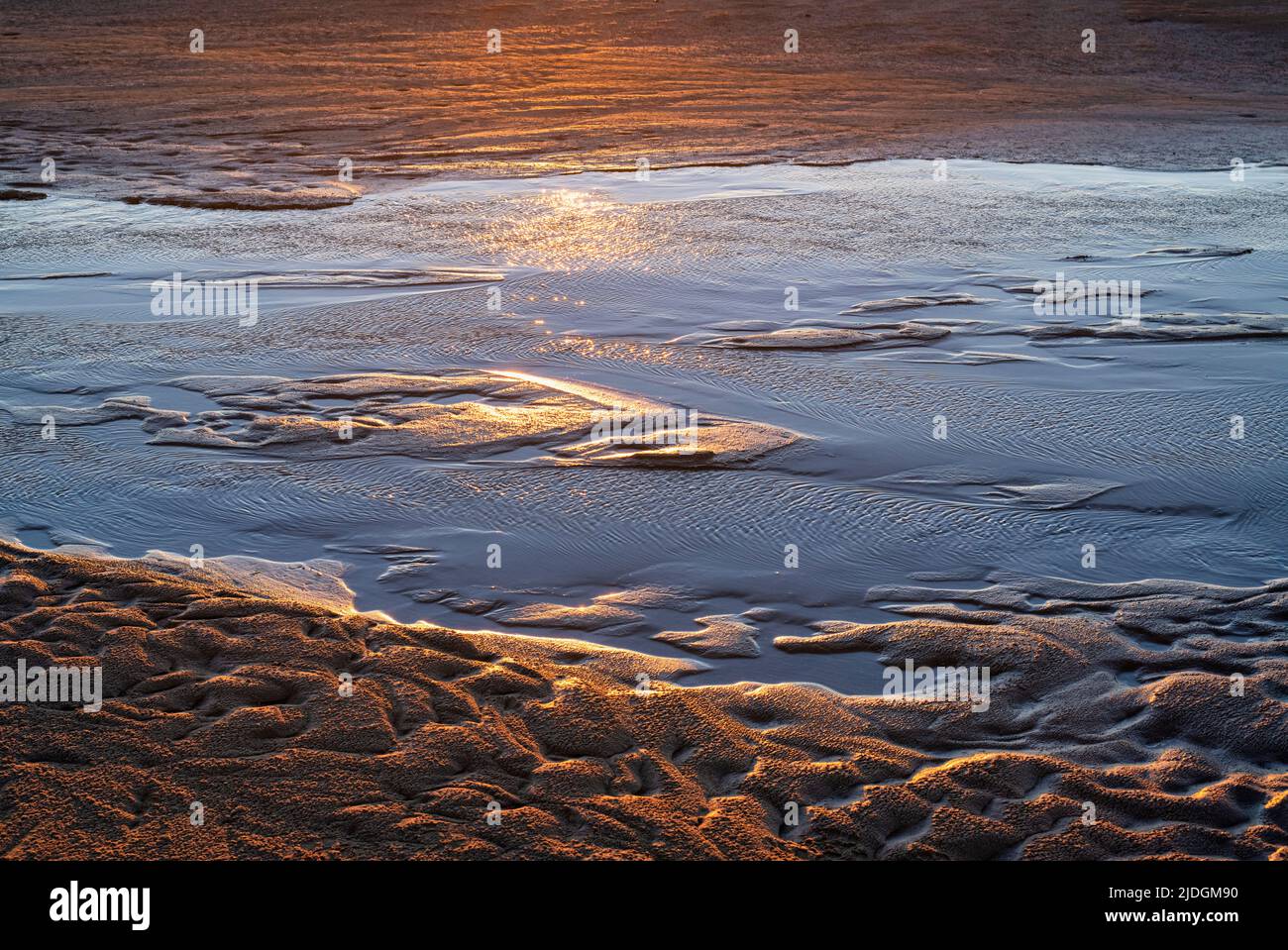 Motif de sable aquatique dans la lumière du coucher du soleil sur la plage de Southherness, Dumfries et Galloway, en Écosse Banque D'Images