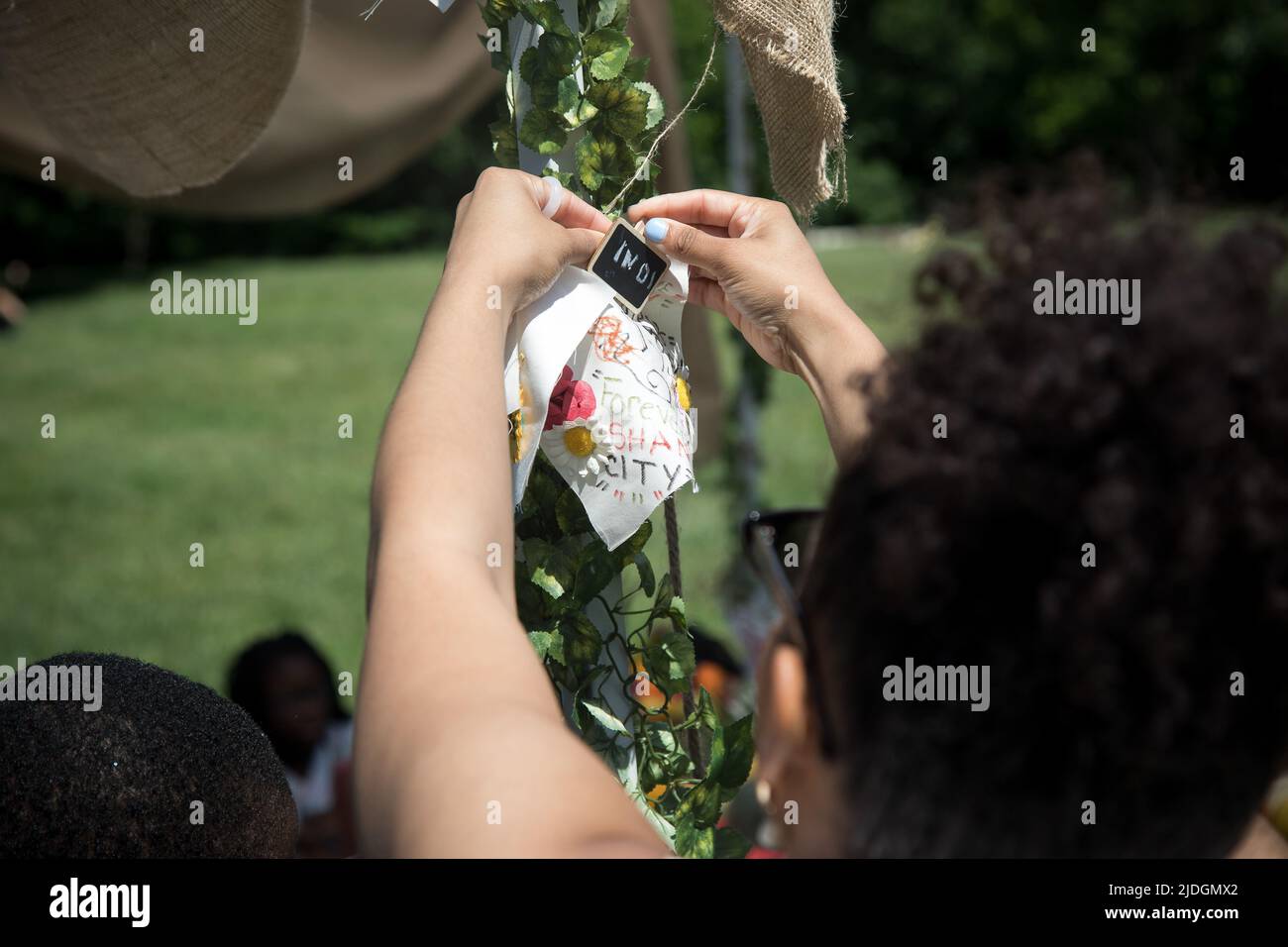 NEW YORK, 21 juin 2022 (Xinhua) -- Chayanne Marcano, conservatrice du projet de courtepointe, est en train de suspendre un timbre pour une courtepointe commémorant les victimes de la pandémie COVID-19 lors du dix-septième Festival annuel de Prospect Park en 13th dans le quartier de Brooklyn à New York, aux États-Unis, sur 19 juin 2022. Les participants ont fait des œuvres d'art ou écrit des mots sur les courtepointes en commémoration des membres de leur famille qui sont morts du coronavirus. Alors que les Afro-Américains de New York se sont joints à d'autres personnes de tout le pays pour commémorer la fin de l'esclavage aux États-Unis, ils ont également honoré les vies perdues du C Banque D'Images