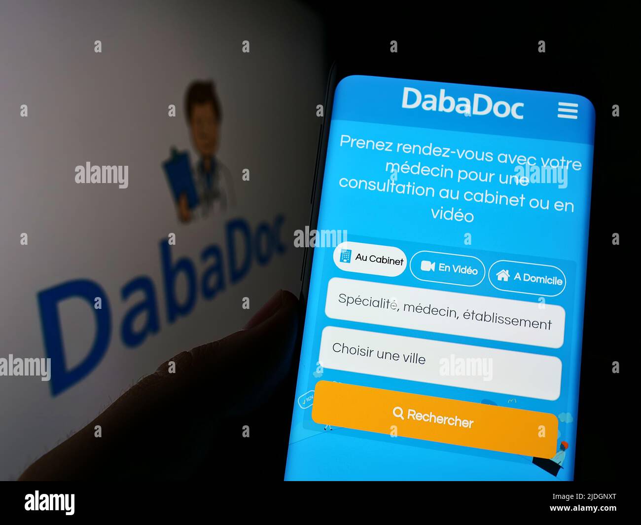 Personne tenant un téléphone portable avec la page web de la société marocaine de soins de santé DabaDoc à l'écran devant le logo. Concentrez-vous sur le centre de l'écran du téléphone. Banque D'Images
