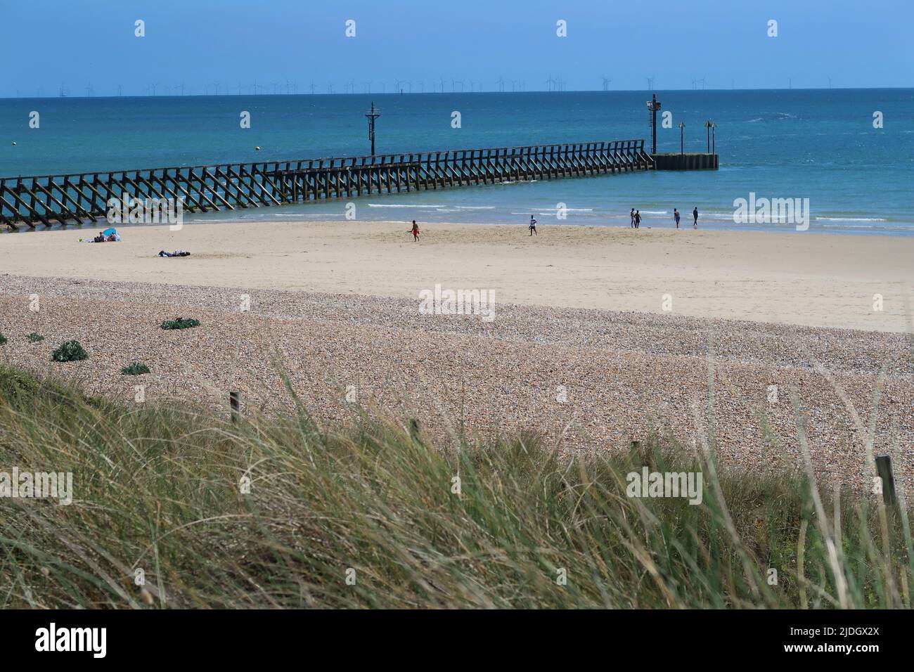 Littlempton, West Sussex, Royaume-Uni. Vue sur les dunes de sable derrière West Beach. Montre le petit-déjeuner à l'entrée de la rivière Arun. Éoliennes à l'horizon. Banque D'Images