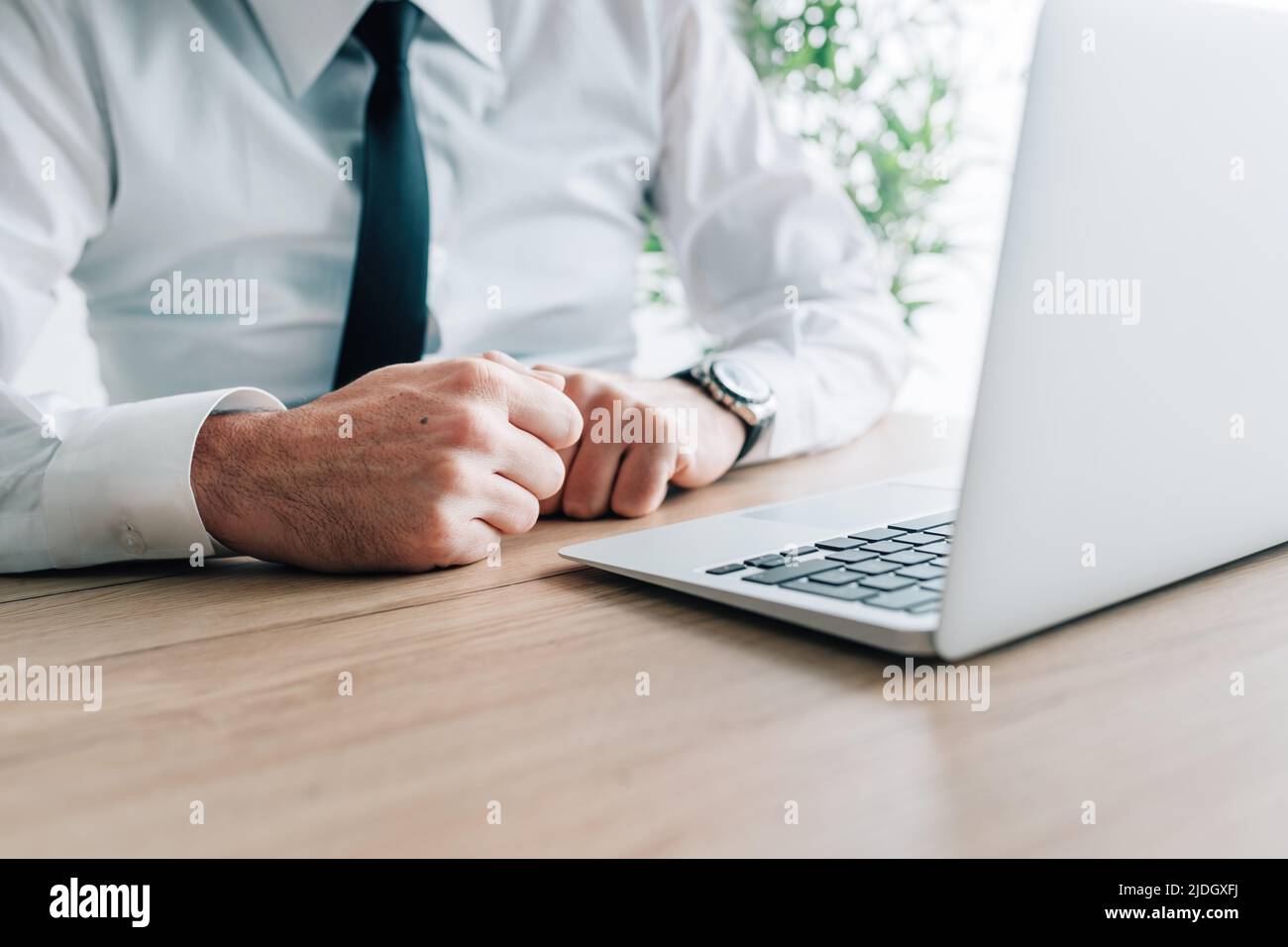 Un homme d'affaires claque les poings devant un ordinateur portable au bureau, une attention sélective Banque D'Images