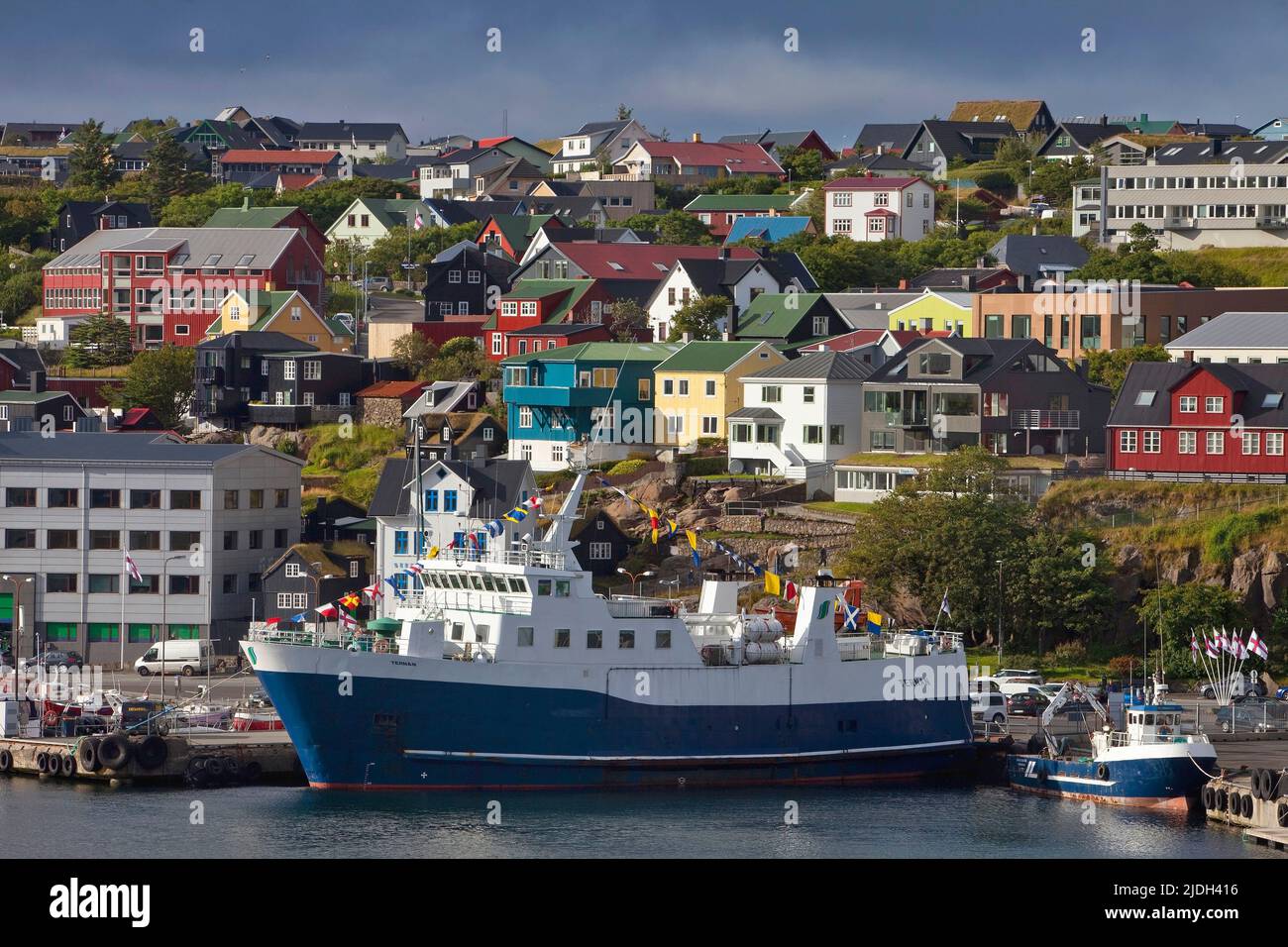 Bateau dans le port avec une vue sur la capitale, les îles Féroé, Streymoy, Torshavn Banque D'Images