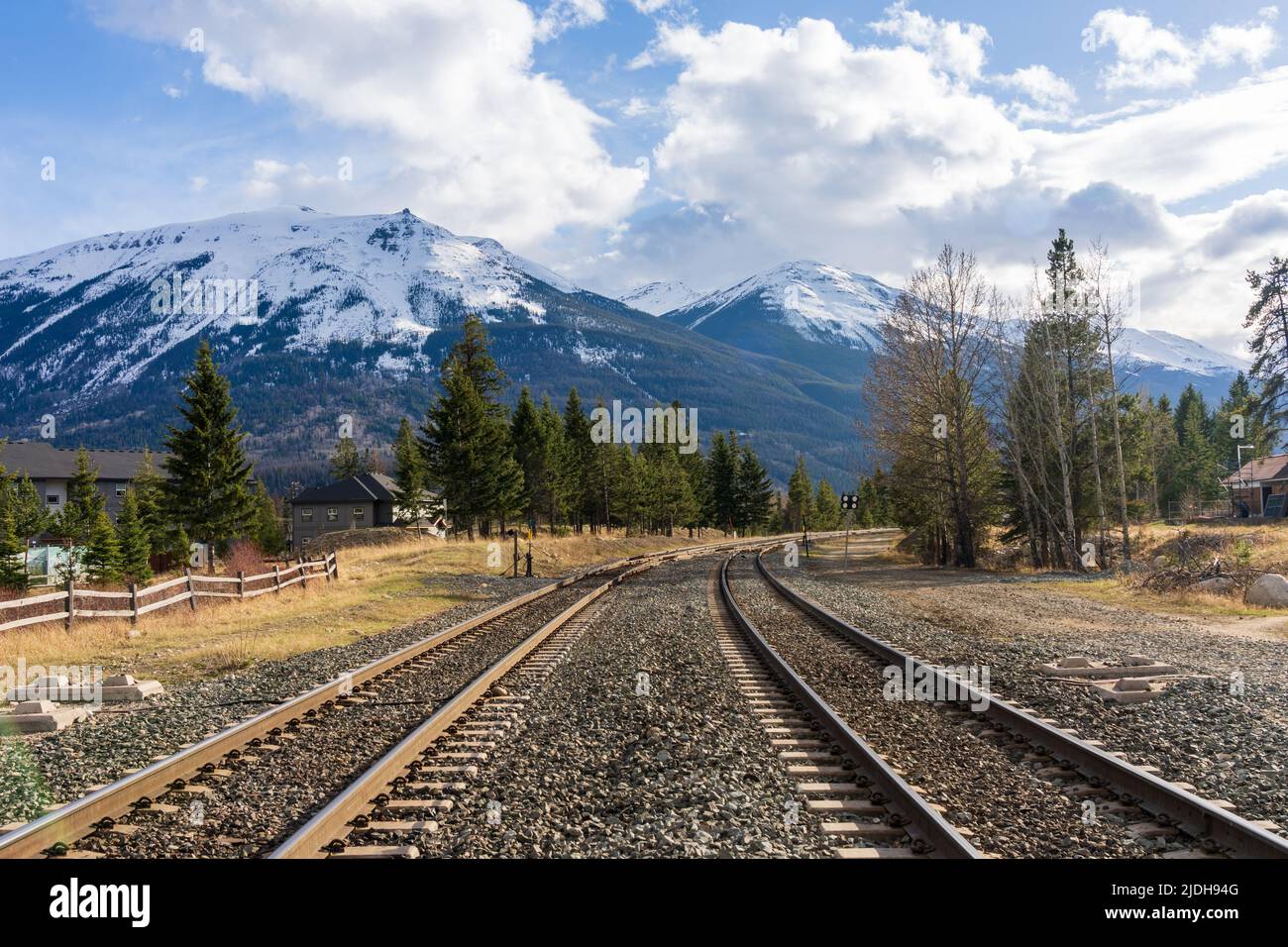 Chemin de fer sur campagne zone rurale. Montagnes enneigées sur ciel bleu nuages blancs. Rocheuses canadiennes Parc national Jasper Whistlers Peak. Banque D'Images