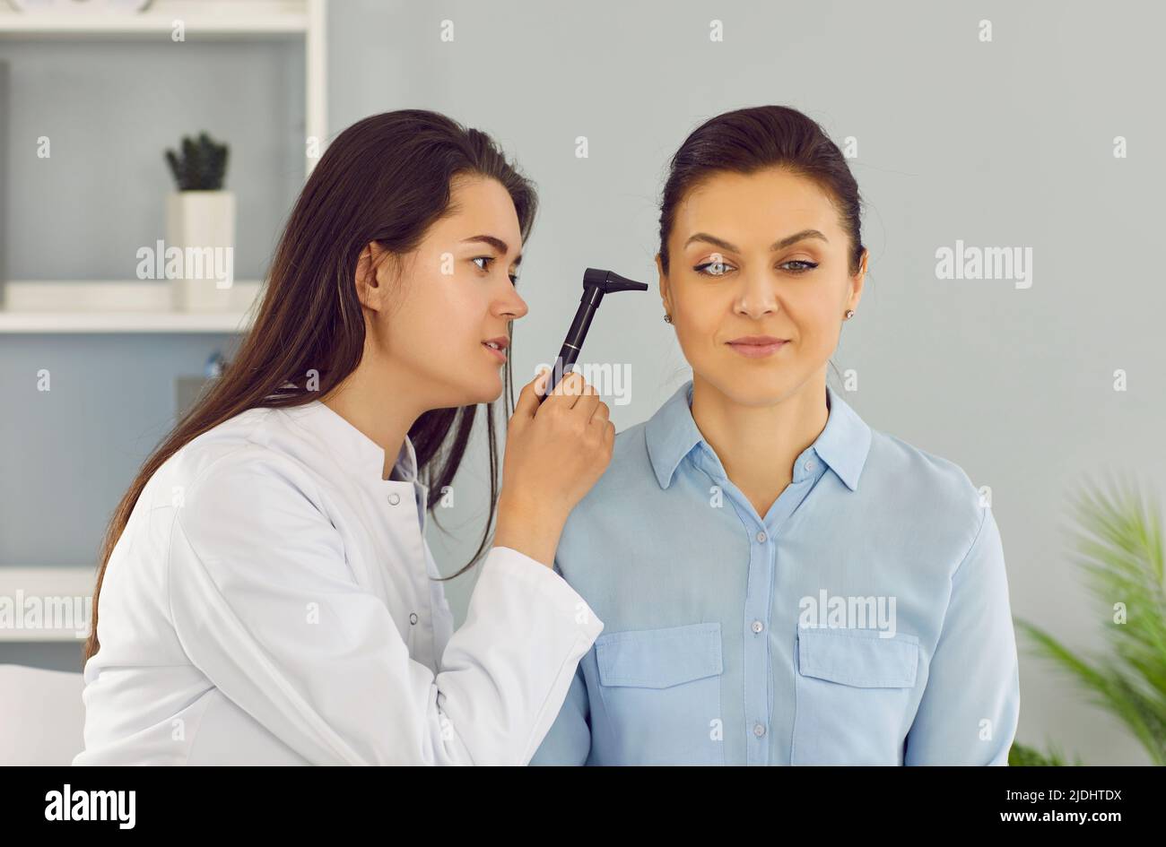 Le médecin ORL utilise l'otoscope pour examiner l'oreille de la patiente pendant un examen médical à l'hôpital. Banque D'Images