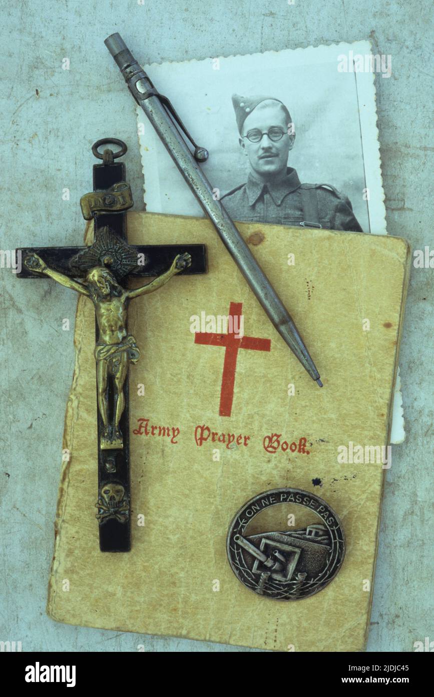 Photo vintage de l'homme dans la guerre mondiale 2 uniforme de l'armée couché avec le bois et le laiton crucifix crayon propulsant livre de prière de l'armée et badge de la ligne Maginot Banque D'Images