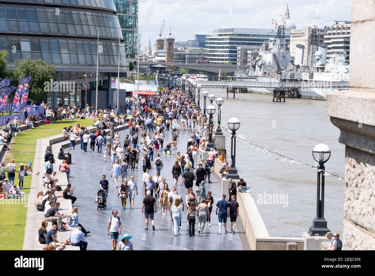 La promenade de la Reine sur la rive sud de la Tamise près de Tower Bridge, Londres, regorgeant de touristes étrangers et de touristes appréciant la journée. Banque D'Images