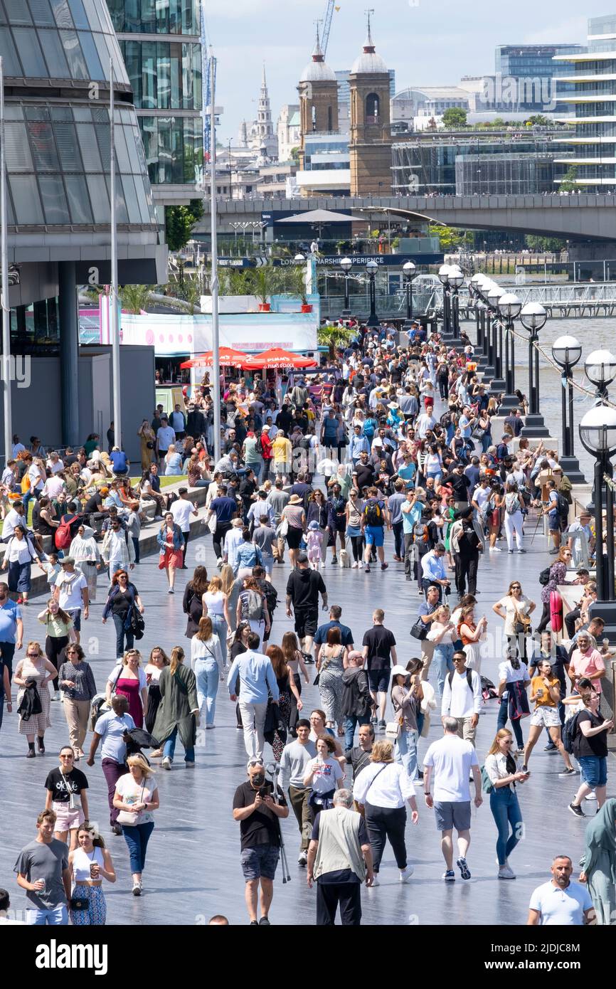 La promenade de la Reine sur la rive sud de la Tamise près de Tower Bridge, Londres, regorgeant de touristes étrangers et de touristes appréciant la journée. Banque D'Images