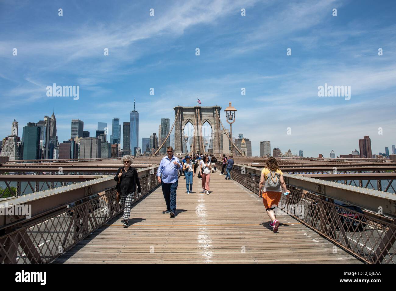 Personnes sur la passerelle piétonnière du pont de Brooklyn avec les immeubles de Manhattan en hauteur en arrière-plan à New York City, États-Unis d'Amérique Banque D'Images