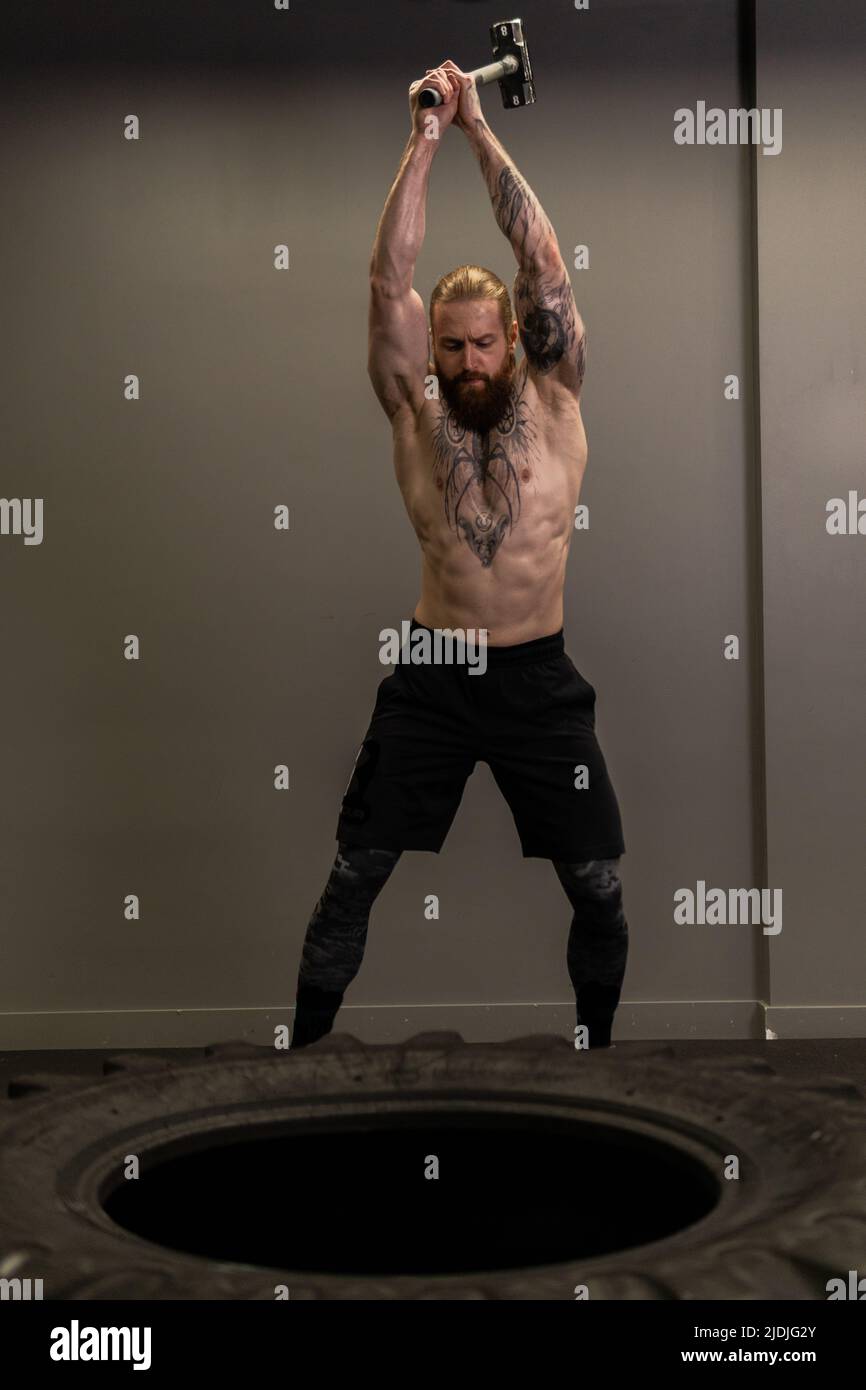 Sledgehammer camion roue roue pneu femme remplacer jeune Hammer gym, pour la concentration d'équipement de l'homme de l'entraînement musculaire, homme adulte Banque D'Images