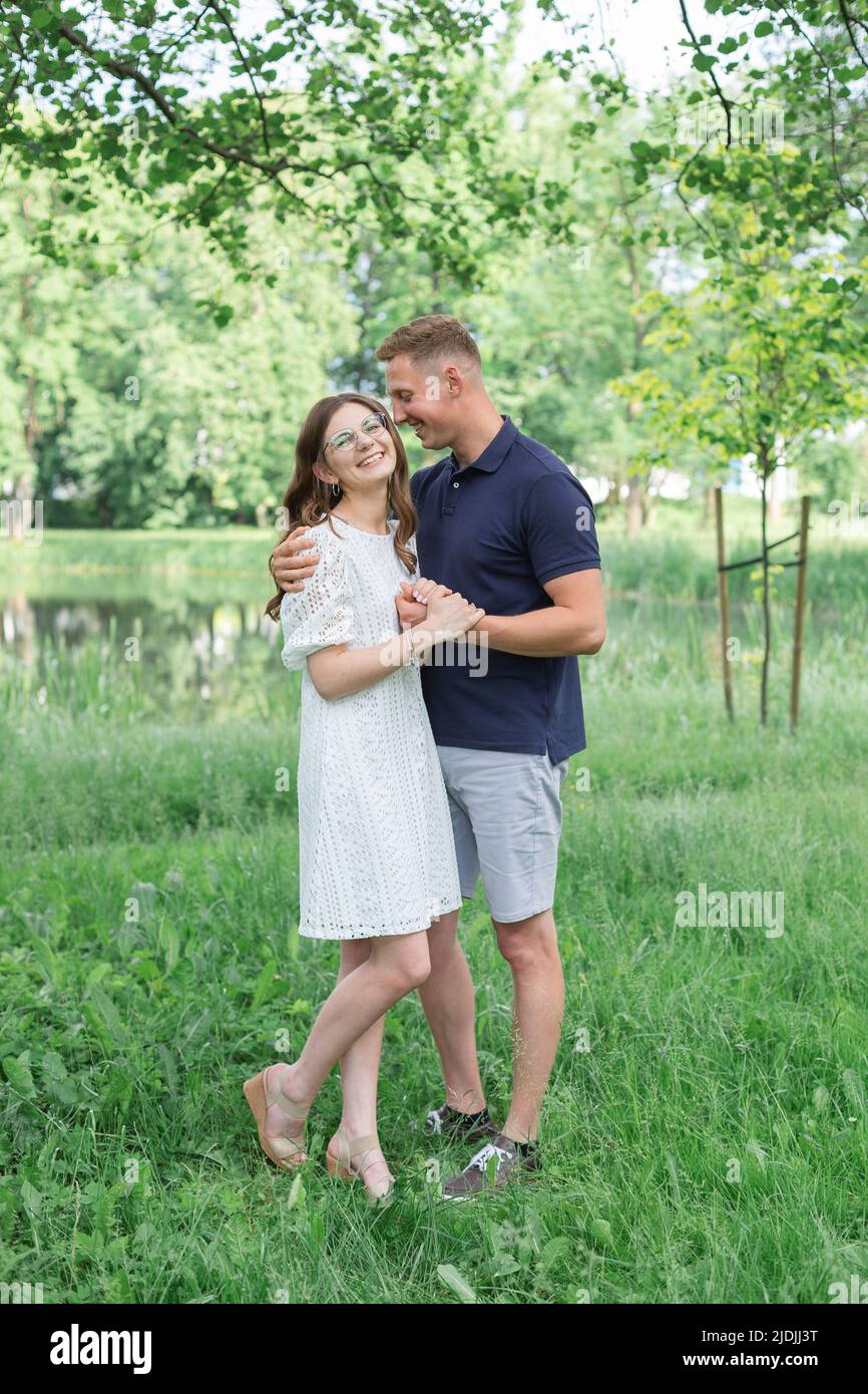 pleine longueur de jeunes couples heureux en été debout dans le parc, embrassant, heureux gens Banque D'Images