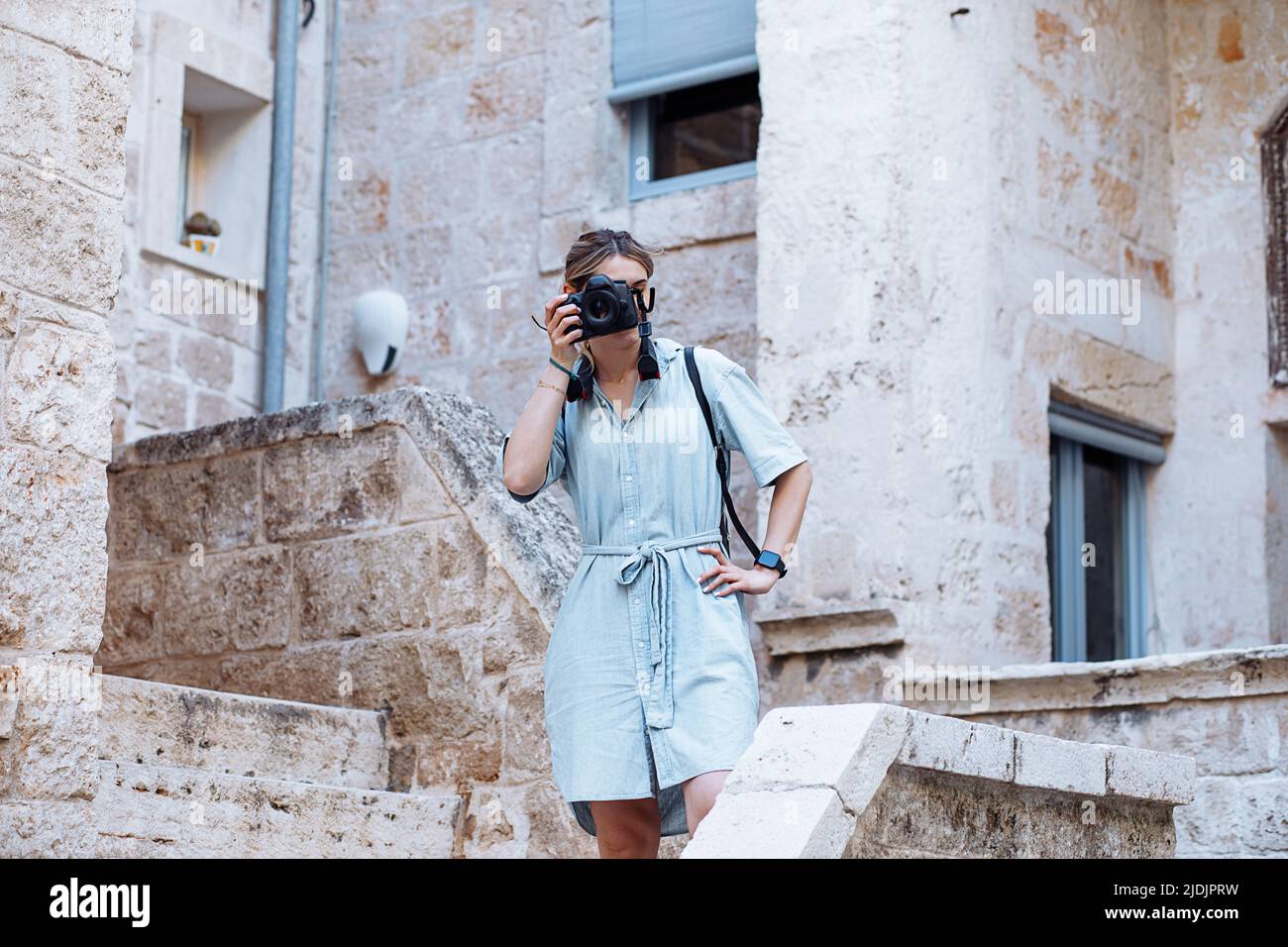 Belle blonde jeune femme prenant des photos avec un appareil photo dans la ville européenne italienne, jeune architecte en vacances Banque D'Images