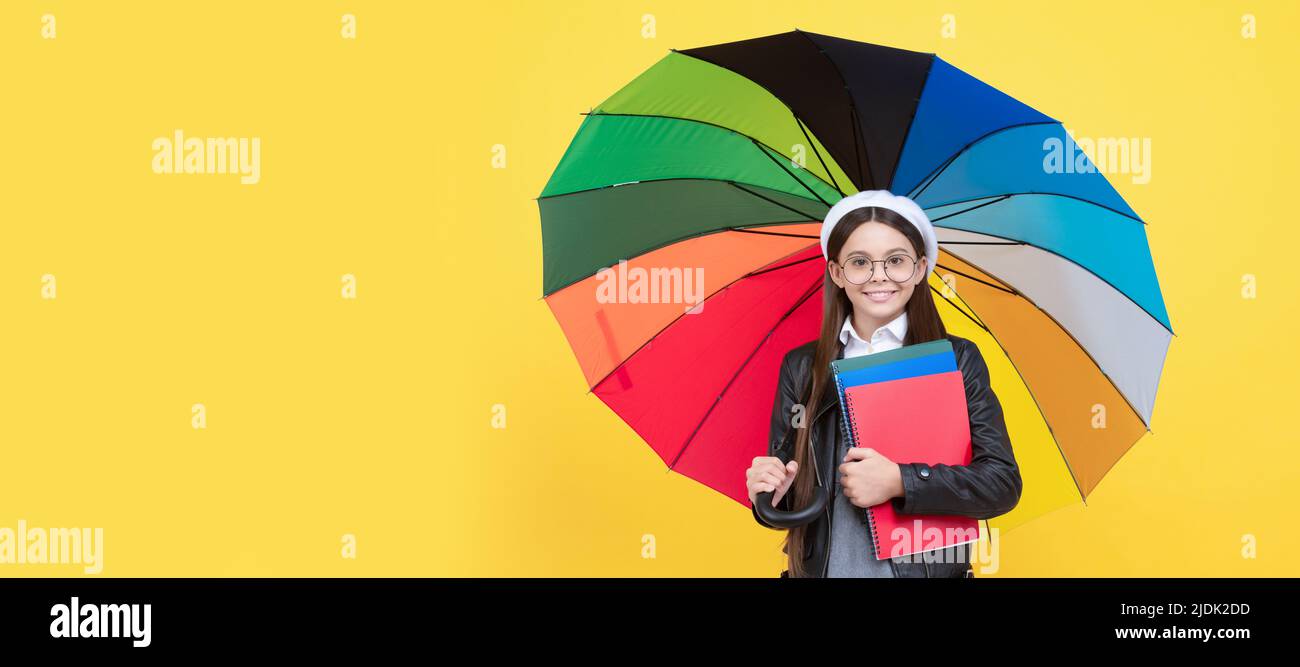 Automne école d'automne. Adolescent sous le parasol coloré. Enfant en béret avec parapluie arc-en-ciel. Saison d'automne. Portrait d'une écolière étudiante, studio Banque D'Images