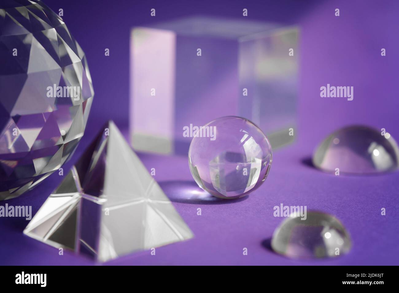 Prisme de cristal réfractant la lumière, les cristaux magiques et la pyramide, la sphère et le cube sur fond violet. Pratique spirituelle de cristal de guérison. Feng Shui, bien Banque D'Images