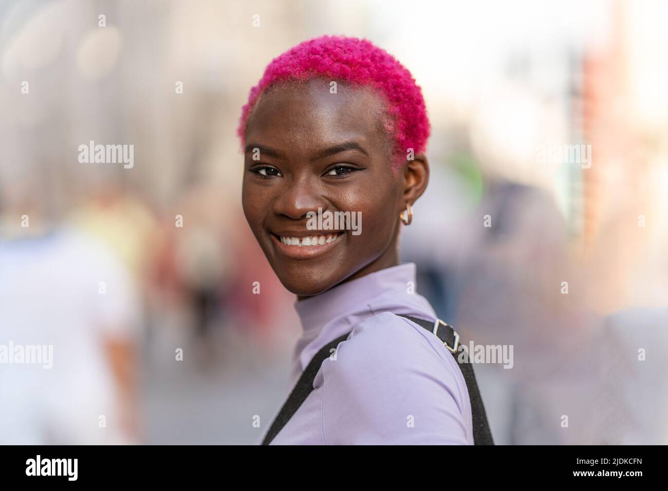 Femme afro moderne et élégante souriant à l'appareil photo Banque D'Images