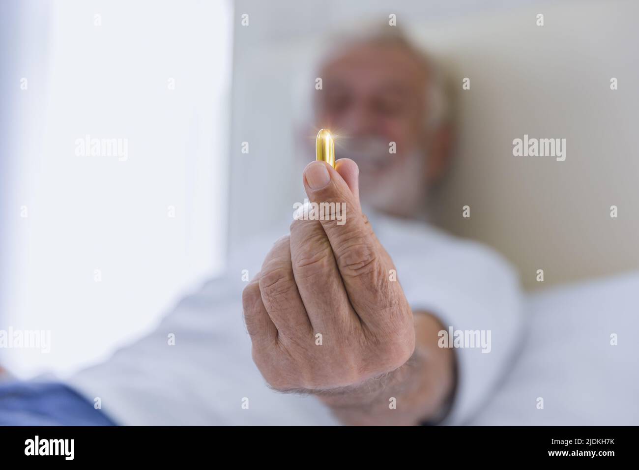 gros plan aîné montrant la pilule de médicaments vitamine poisson huile gel capsule. senior soins de santé médicaments concept de pharmacie. Banque D'Images