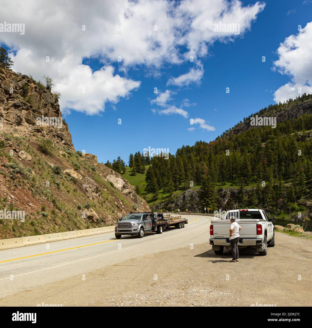 Femme debout près de la voiture en panne en attente de l'aide. Camions sur une route de Mountan à Keremeos Colombie-Britannique Canada. Photo de voyage J Banque D'Images