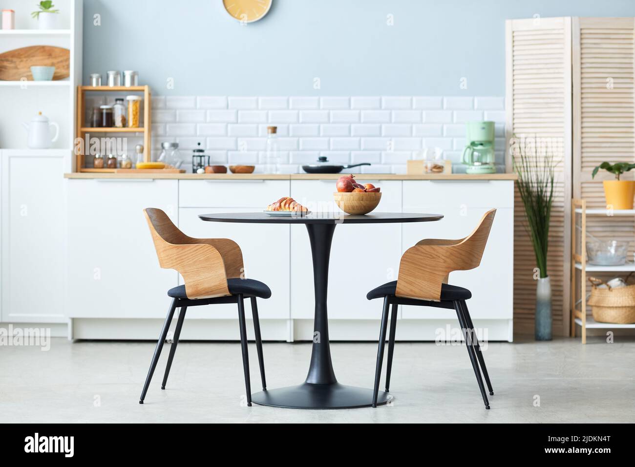Vue latérale minimale d'une table et de chaises élégantes en bois avec détails noirs dans un minimum d'intérieur de cuisine, espace de copie Banque D'Images