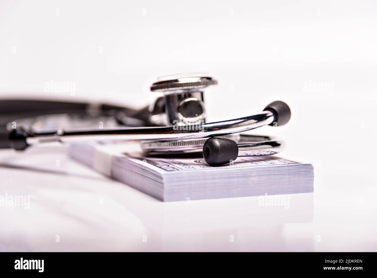 Concept médical - stéthoscope sur les billets de dollars isolés sur fond blanc. Banque D'Images