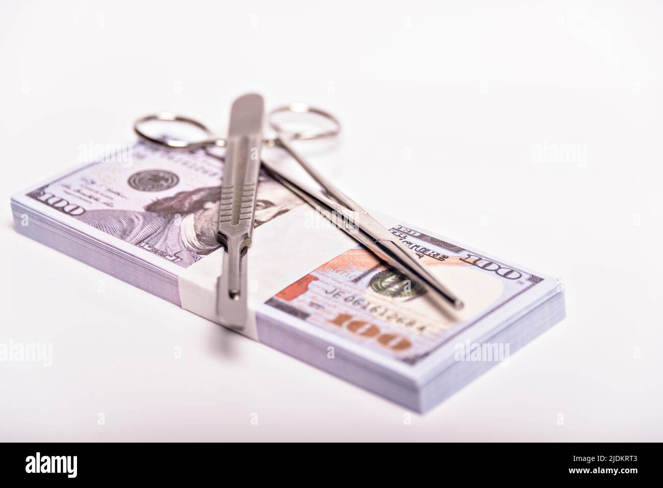 Scalpel et pincettes sur pile de billets d'argent. Concept chirurgie coûteuse, assurance médicale. Banque D'Images