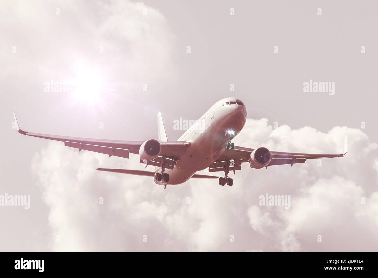 Ciel avec nuages et soleil avec une ombre chaude, lumière réfléchie, gros avion passager atterrissage approche l'aéroport Banque D'Images