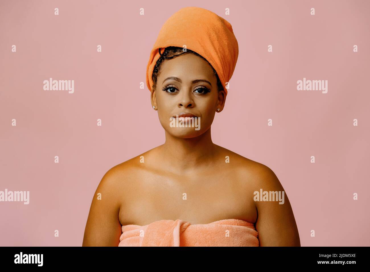 belle femme noire souriante avec une peau parfaite dans une serviette regardant la prise de vue en studio Banque D'Images