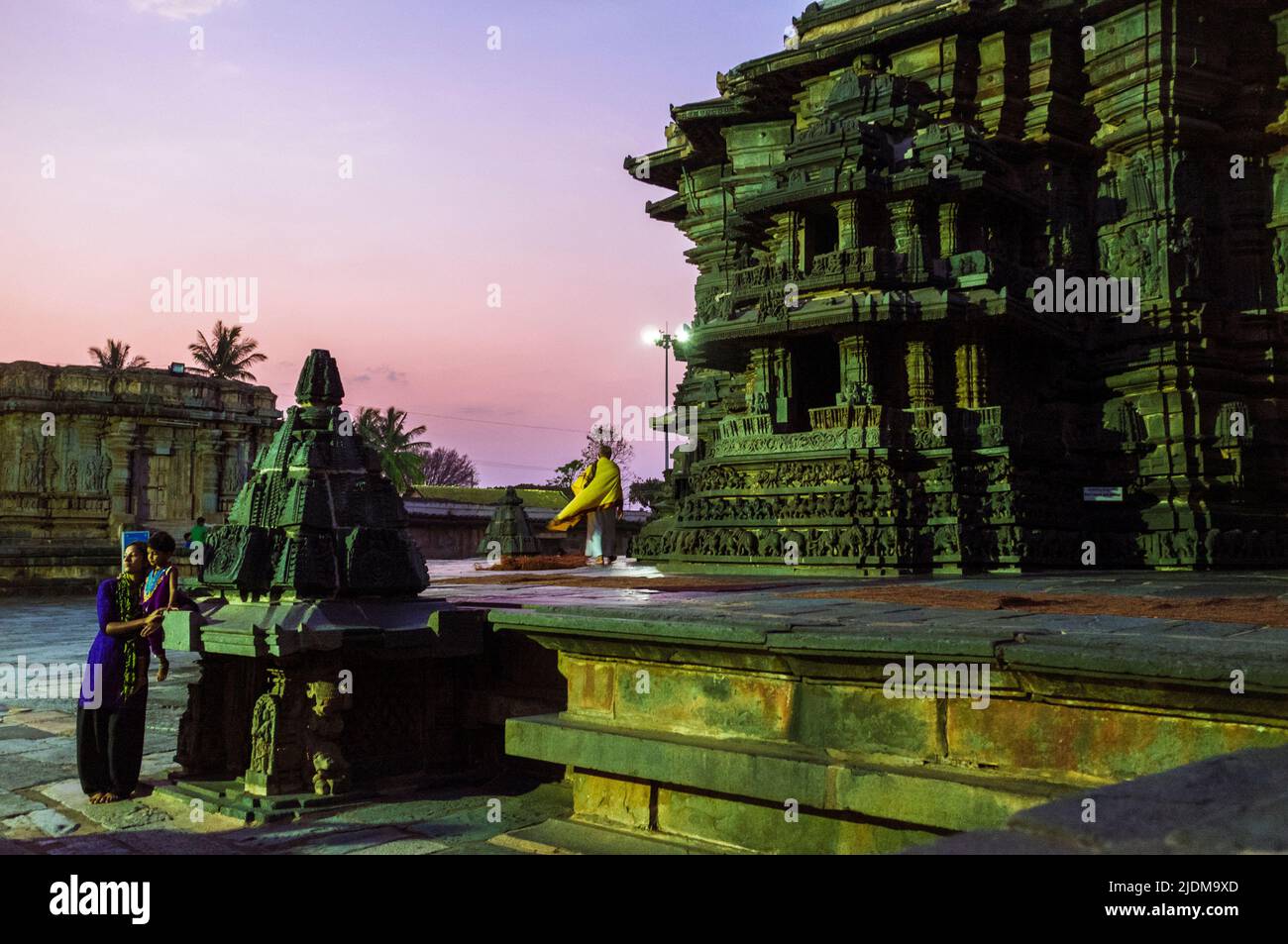 Belur, Karnataka, Inde : Temple Chennakhava du XIIe siècle. Un prêtre hindou marche au coucher du soleil sur la plate-forme jagati pour la cirambulation (pradakshina-p Banque D'Images