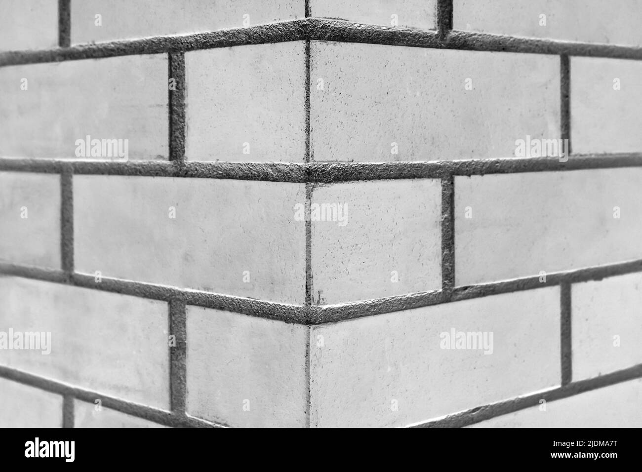 La colonne en brique d'angle fragmente l'architecture de la paroi grise du joint de l'arrière-plan de texture intérieure. Banque D'Images