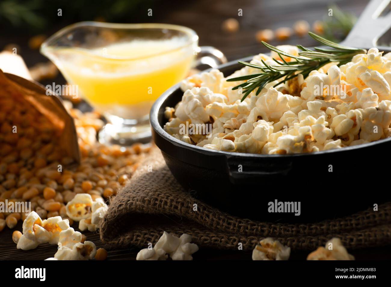 Pop-corn dans une poêle en fonte avec du beurre fondu de côté Banque D'Images