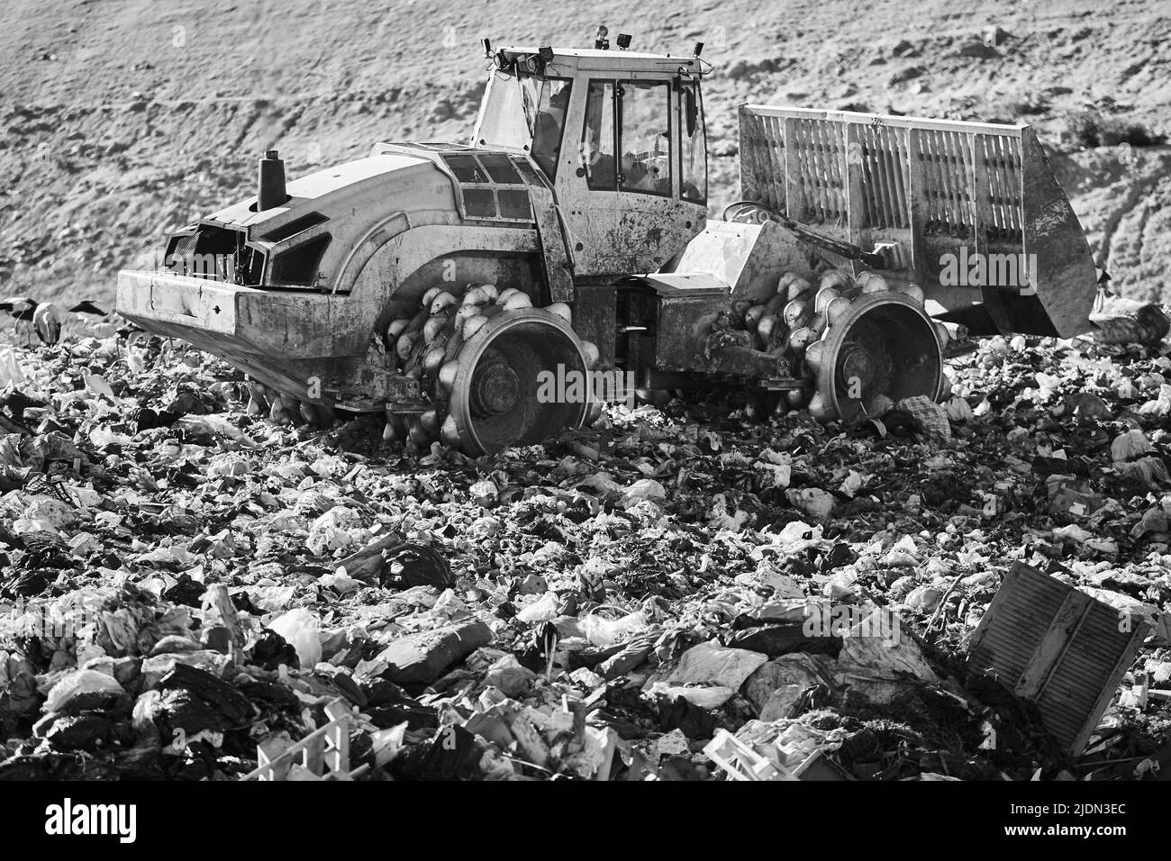 Les machines lourdes déchiquetent les déchets dans une décharge à ciel ouvert. Déchets Banque D'Images