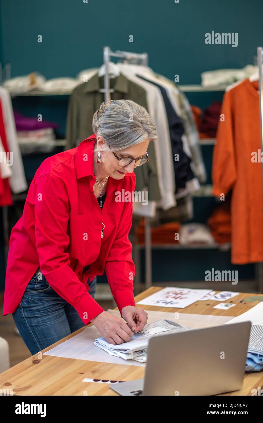 Femme emballant soigneusement les vêtements pliés sur la table Banque D'Images