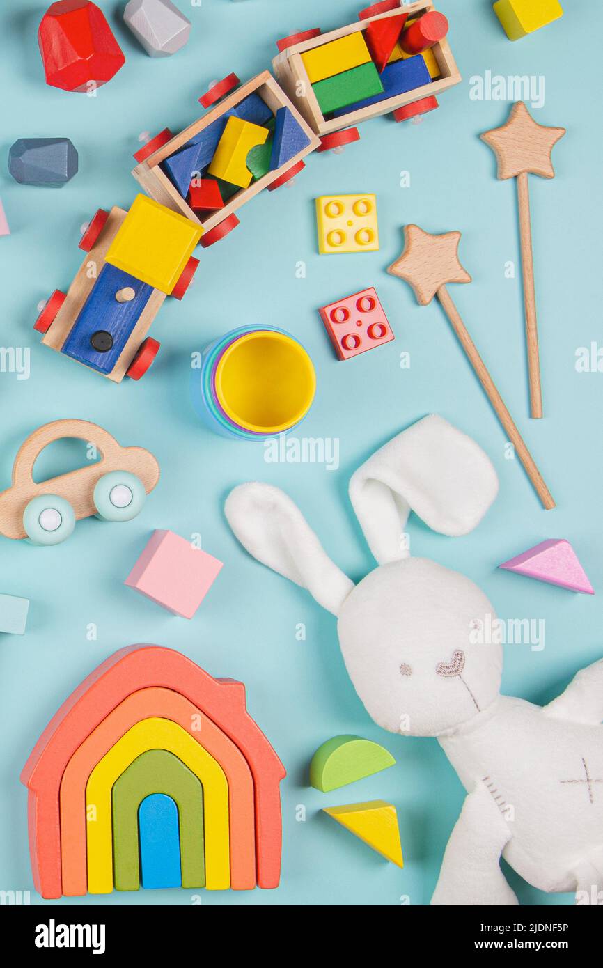 Motif de jouets pour bébés enfants. Ensemble de jouets éducatifs en bois et molletonnés colorés sur fond bleu. Vue de dessus, plan d'appartement Banque D'Images