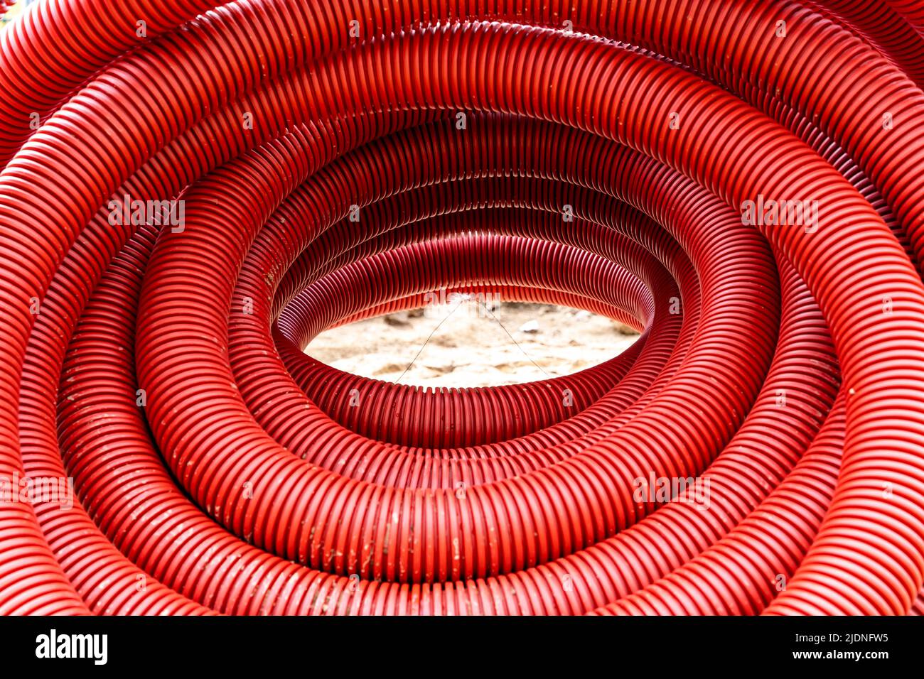 tuyau en pvc ondulé rouge pour la pose de câbles électriques souterrains Banque D'Images