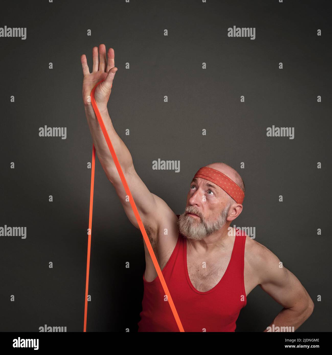 portrait de la tête et de l'épaule de l'homme âgé (fin 60s) s'exerçant avec la bande de résistance, forme physique au-dessus de 60 concept Banque D'Images