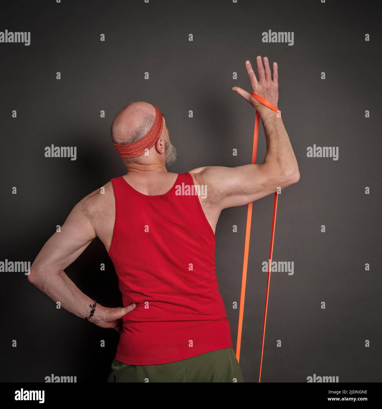 portrait de la tête et de l'épaule de l'homme âgé (fin 60s) s'exerçant avec la bande de résistance, forme physique au-dessus de 60 concept Banque D'Images