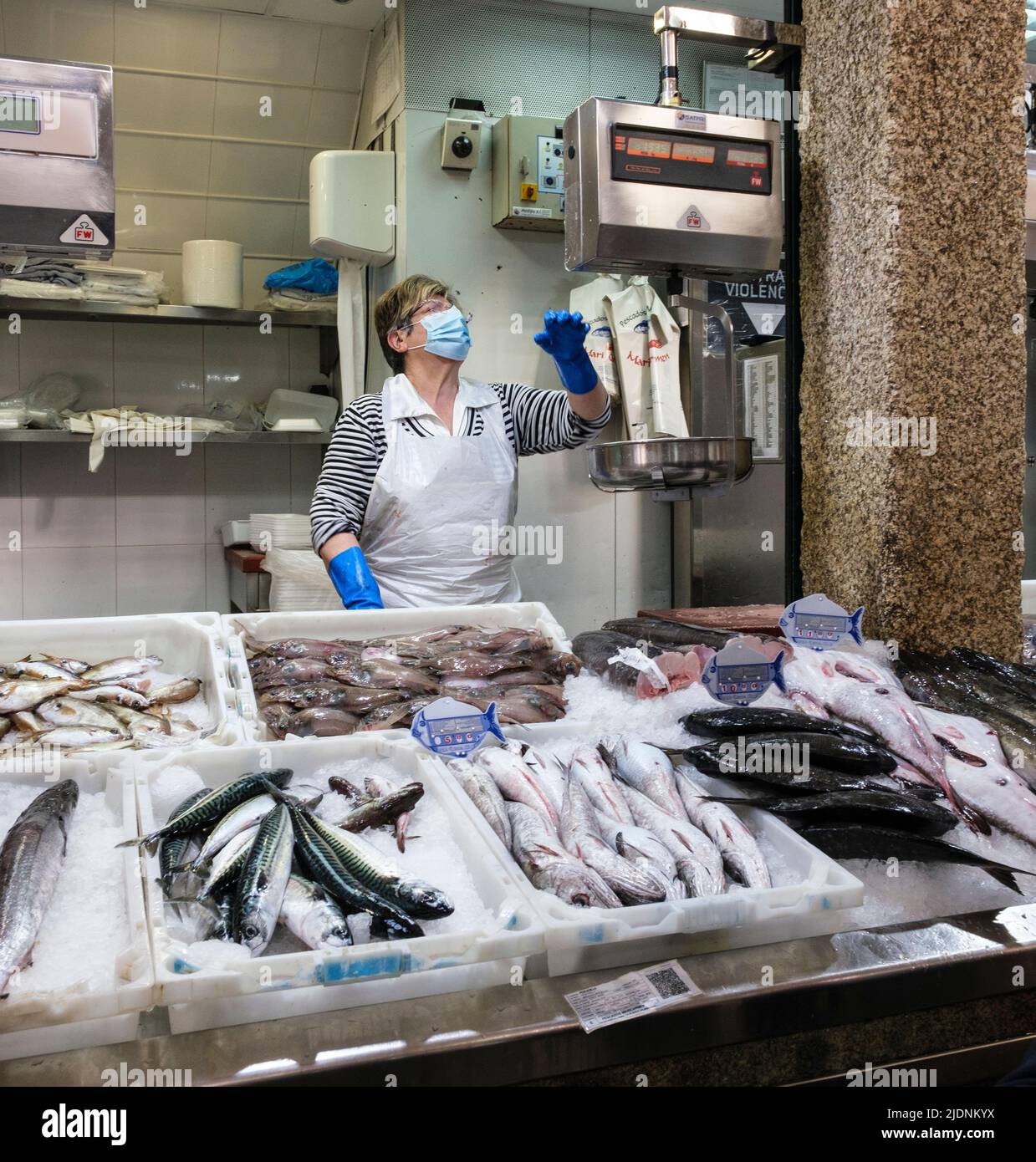 Espagne, Saint-Jacques-de-Compostelle, Galice. Fournisseur de produits de la mer pesant un achat pour un client sur le marché. Banque D'Images