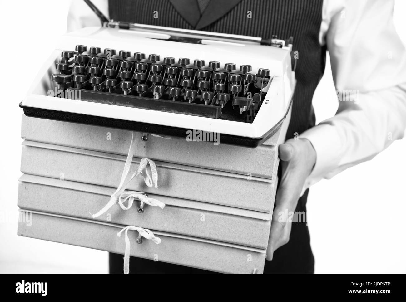 machine à écrire rétro et tas de dossiers dans les mains des hommes, travail Banque D'Images