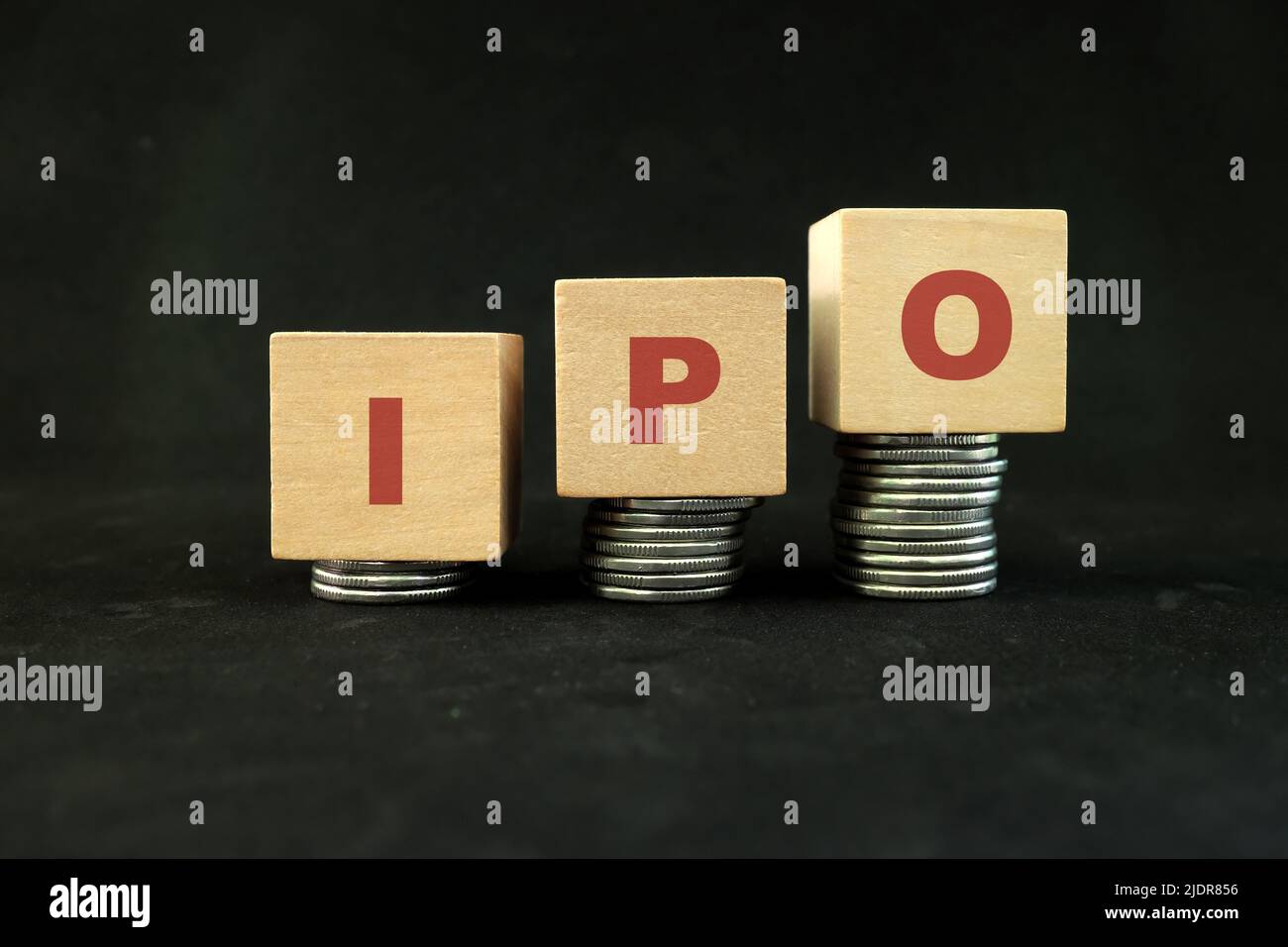 Concept initial de croissance de l'investissement sur le marché boursier. Les lettres IPO dans la pile croissante de pièces sur fond noir foncé. Banque D'Images